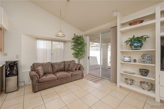 living room with built in shelves, plenty of natural light, light tile patterned flooring, and vaulted ceiling