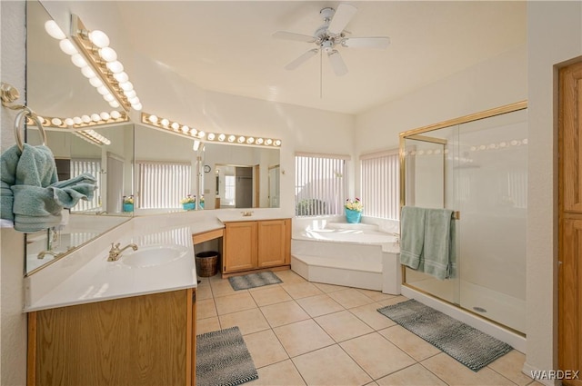 bathroom featuring tile patterned flooring, a shower stall, two vanities, and a sink