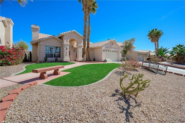 mediterranean / spanish-style home with an attached garage, a front yard, a chimney, and stucco siding