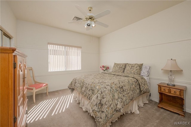 carpeted bedroom featuring visible vents and a ceiling fan