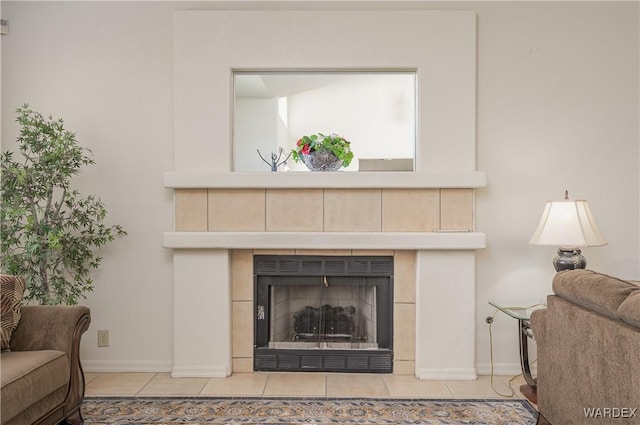 living area with light tile patterned floors, baseboards, and a tiled fireplace