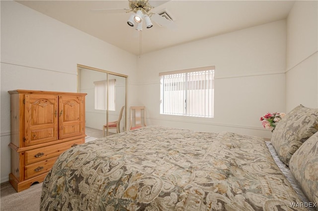 bedroom with light carpet, ceiling fan, visible vents, and a closet