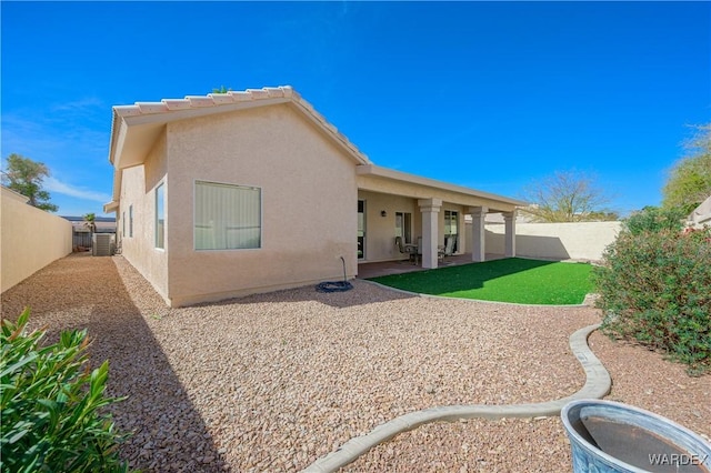 back of property featuring a fenced backyard, a patio area, central AC, and stucco siding