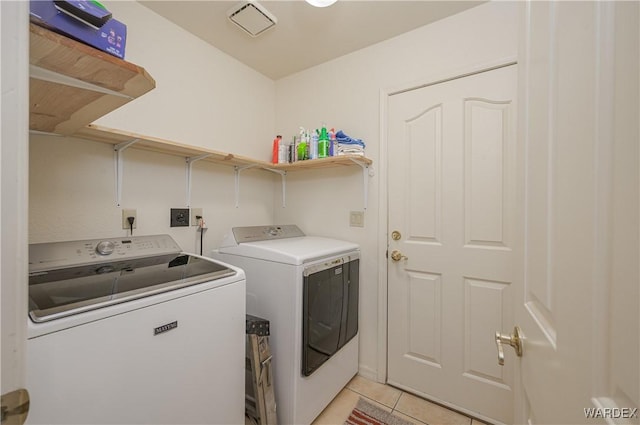 laundry room featuring laundry area, light tile patterned floors, and separate washer and dryer