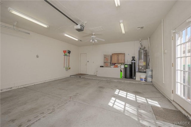 garage featuring a garage door opener, gas water heater, and visible vents