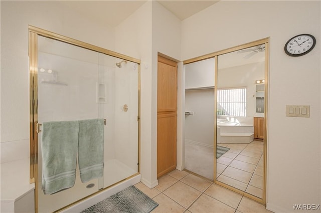 bathroom with a stall shower, tile patterned flooring, and a garden tub