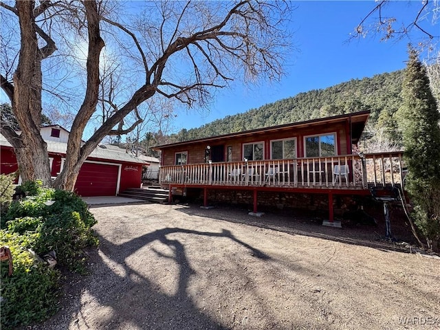 view of front of property with a detached garage and a wooden deck