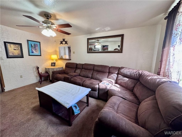 living room featuring ceiling fan, dark colored carpet, and a textured wall