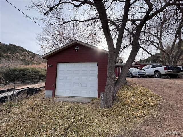 detached garage featuring fence