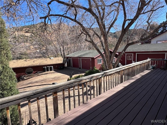 wooden deck featuring concrete driveway and a mountain view