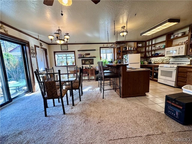 kitchen featuring white appliances, a kitchen island, ornamental molding, open shelves, and a kitchen bar