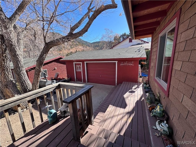 wooden deck with a garage and a mountain view