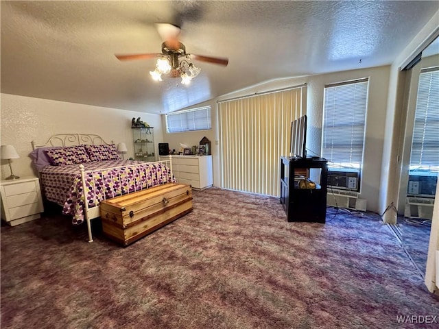 bedroom featuring a textured ceiling, a textured wall, cooling unit, a ceiling fan, and dark carpet