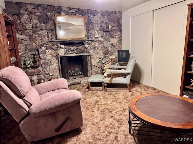 living area with carpet flooring and a stone fireplace