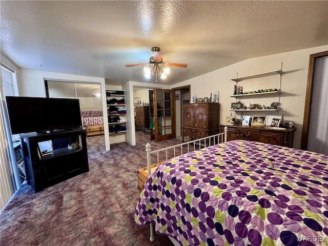 carpeted bedroom with two closets, ceiling fan, and a textured ceiling