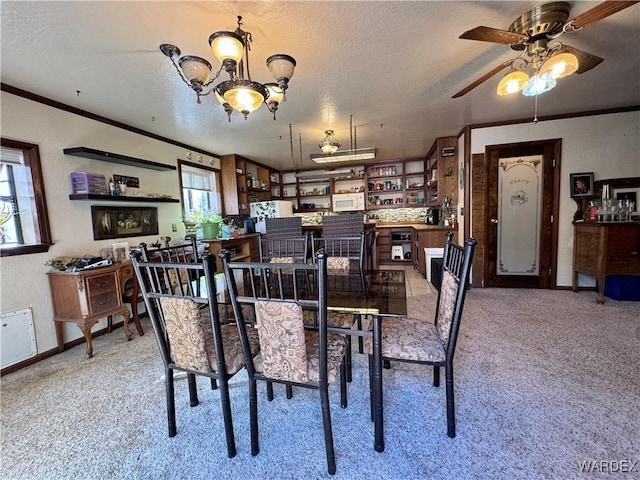 carpeted dining area with a textured ceiling, ornamental molding, baseboards, and a healthy amount of sunlight