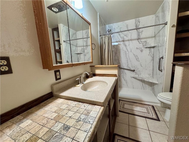 full bathroom featuring toilet, a stall shower, vanity, and baseboards