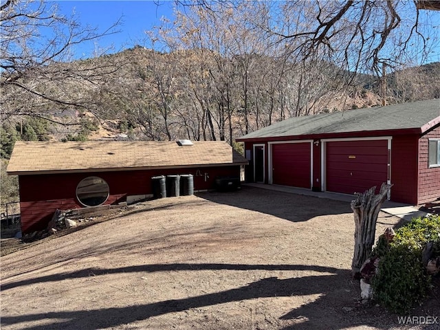 exterior space featuring dirt driveway and a mountain view