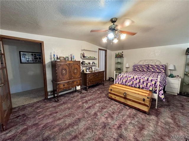 bedroom featuring a textured wall, ceiling fan, vaulted ceiling, dark colored carpet, and a textured ceiling