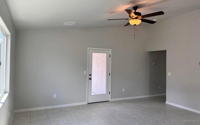 spare room featuring lofted ceiling, a ceiling fan, and baseboards