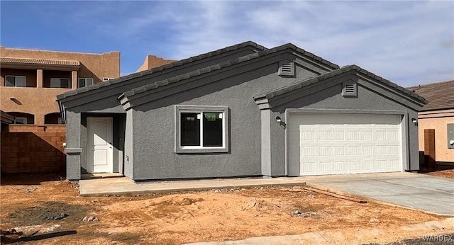 view of front of property featuring a garage, driveway, and stucco siding