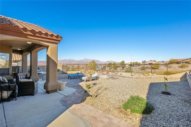 view of yard with a fenced backyard, a mountain view, and a patio