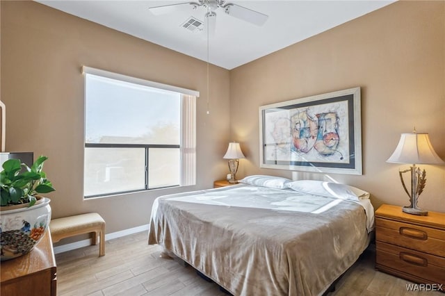 bedroom featuring ceiling fan, light wood finished floors, visible vents, and baseboards