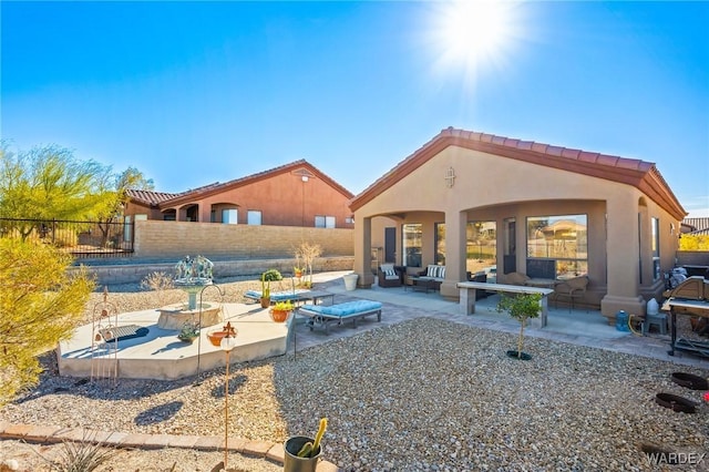 rear view of property featuring a patio area, fence, outdoor lounge area, and stucco siding