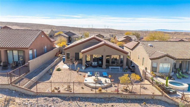 back of house with a fenced backyard, a residential view, a patio area, a mountain view, and stucco siding