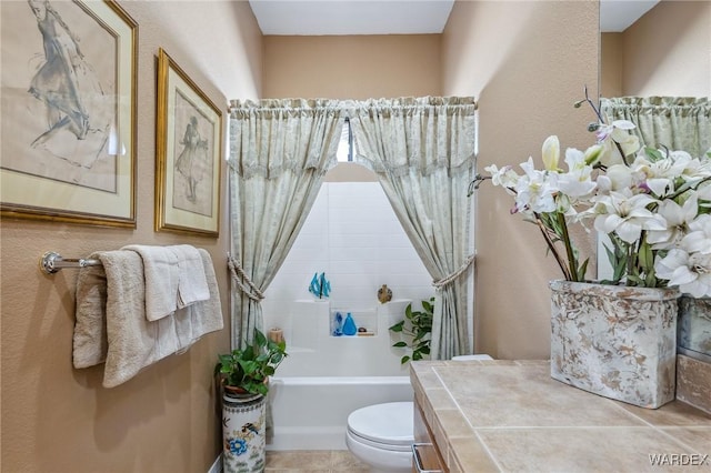 bathroom featuring a textured wall, a washtub, tile patterned flooring, and toilet