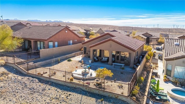 rear view of house with a fenced backyard, a residential view, a patio, and a tile roof