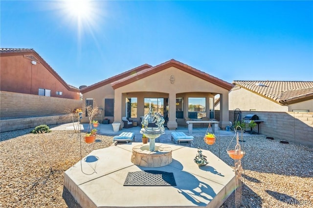 rear view of property featuring a patio area, a fenced backyard, and stucco siding