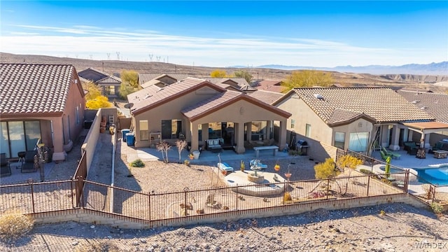 rear view of house featuring a patio, stucco siding, a mountain view, a residential view, and a fenced backyard