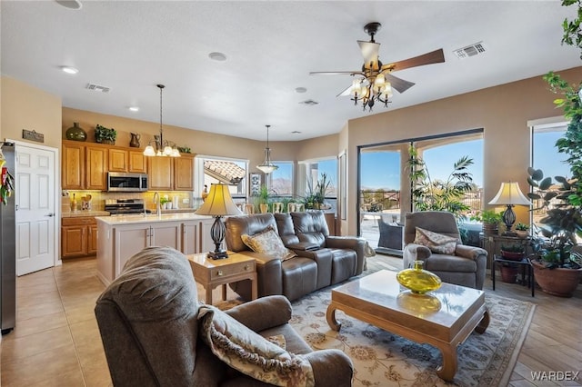 living room featuring a healthy amount of sunlight, visible vents, and ceiling fan