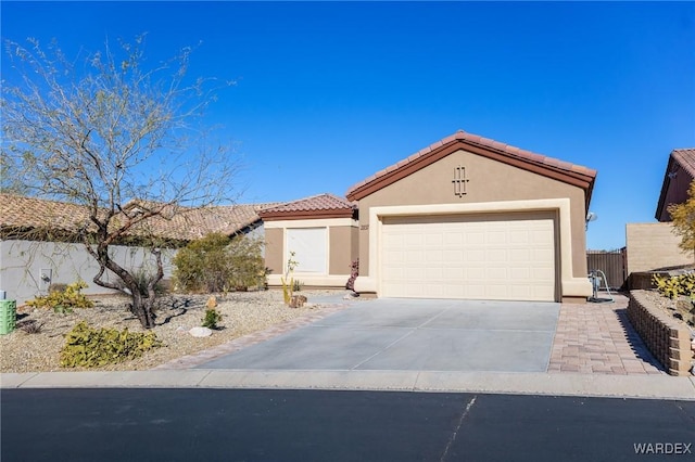 view of front of home with driveway, a garage, a tiled roof, fence, and stucco siding