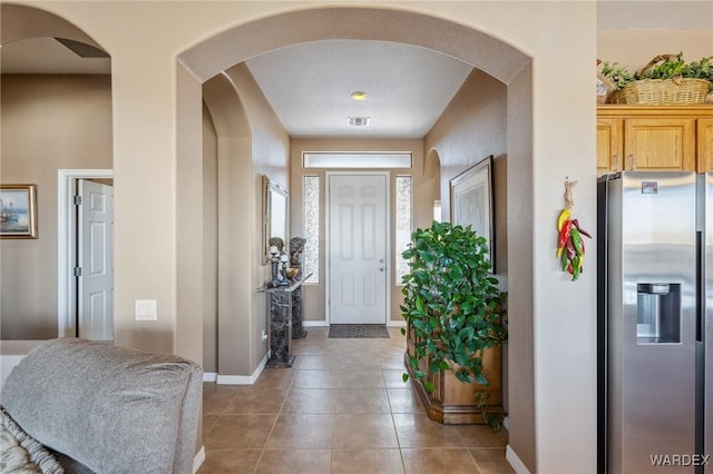 tiled foyer entrance featuring visible vents and baseboards