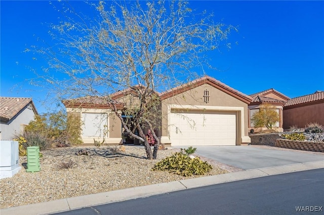 view of front of property with a garage, concrete driveway, a tile roof, and stucco siding