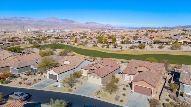 drone / aerial view featuring view of golf course, a residential view, and a mountain view