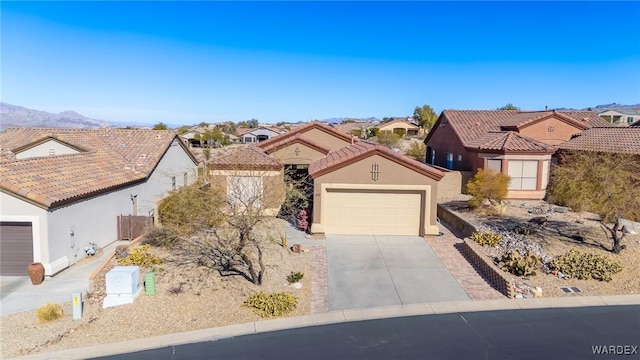 view of front of home with driveway, a tile roof, a residential view, a mountain view, and stucco siding