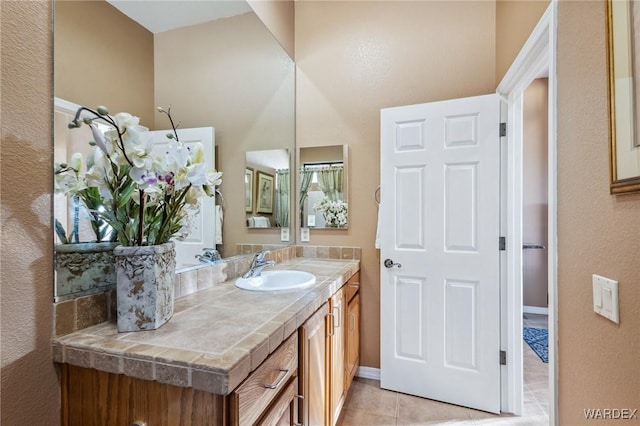 bathroom featuring tile patterned flooring, baseboards, and vanity