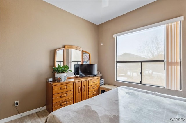 bedroom featuring baseboards and wood finished floors