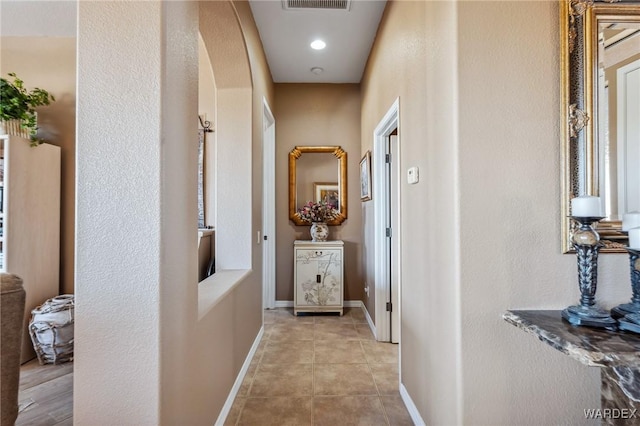 hallway featuring light tile patterned floors, recessed lighting, visible vents, and baseboards