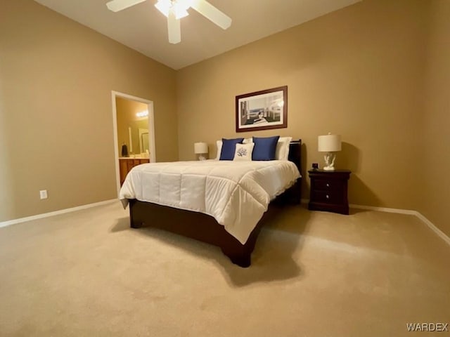 carpeted bedroom with ensuite bath, ceiling fan, and baseboards