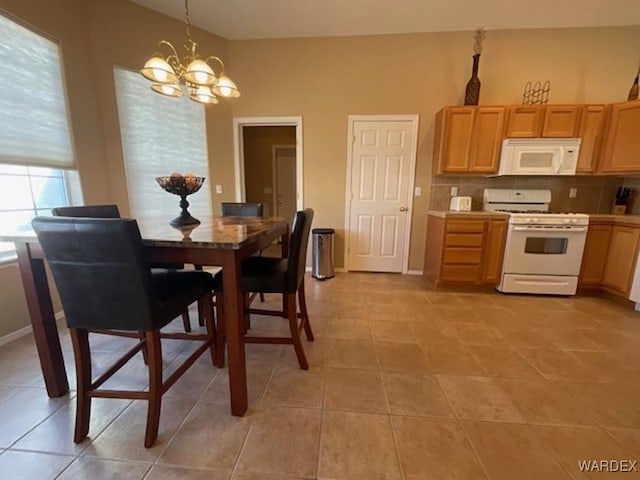 dining room with light tile patterned floors, baseboards, and a notable chandelier