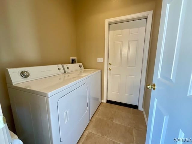 laundry room with washing machine and dryer, laundry area, baseboards, and light tile patterned floors