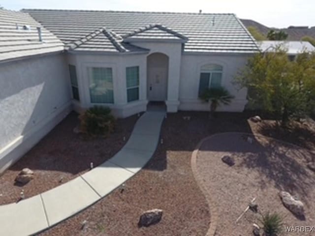 view of front of property featuring a tile roof and stucco siding