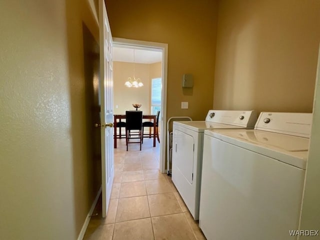 laundry area with light tile patterned floors, a chandelier, laundry area, baseboards, and independent washer and dryer