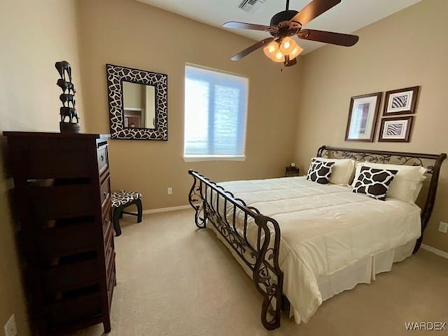 bedroom featuring visible vents, baseboards, a ceiling fan, and light colored carpet