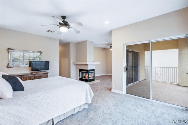 carpeted bedroom featuring ceiling fan, a multi sided fireplace, visible vents, access to exterior, and baseboards