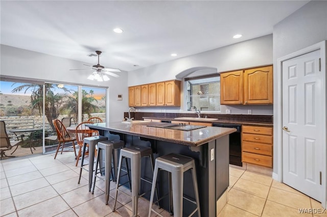 kitchen with light tile patterned floors, black dishwasher, a kitchen island, a kitchen breakfast bar, and recessed lighting